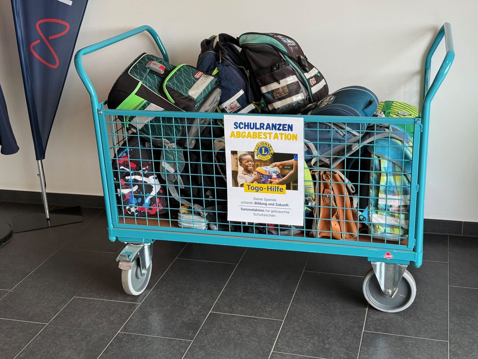 Wagen mit Plakat, gefüllt mit Schulranzen
